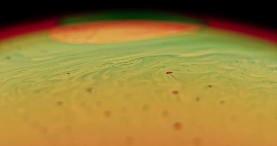 Particles move across the surface of an orb as red circles a yellow spot and green blends into yellow as it moves