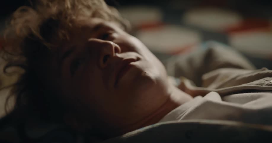 A young man laying on bed happily having an imagination