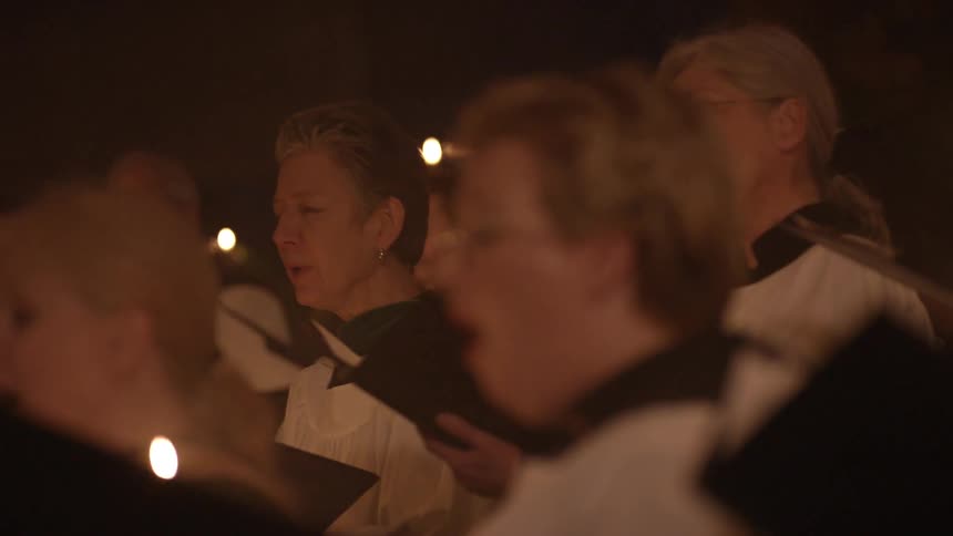 A church choir performing during a candlelight evening service