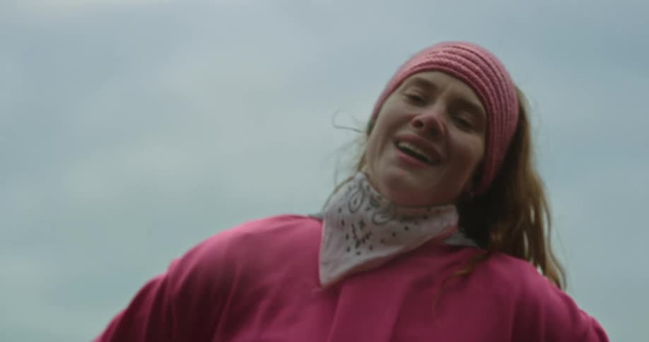 Woman walking outdoors smiles while she catches her breath after exercising