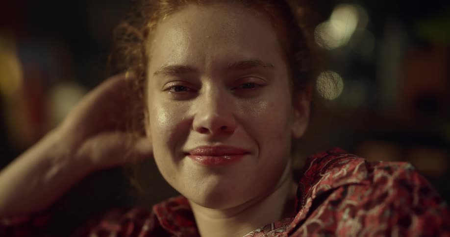 A woman opens her eyes and smiles wide