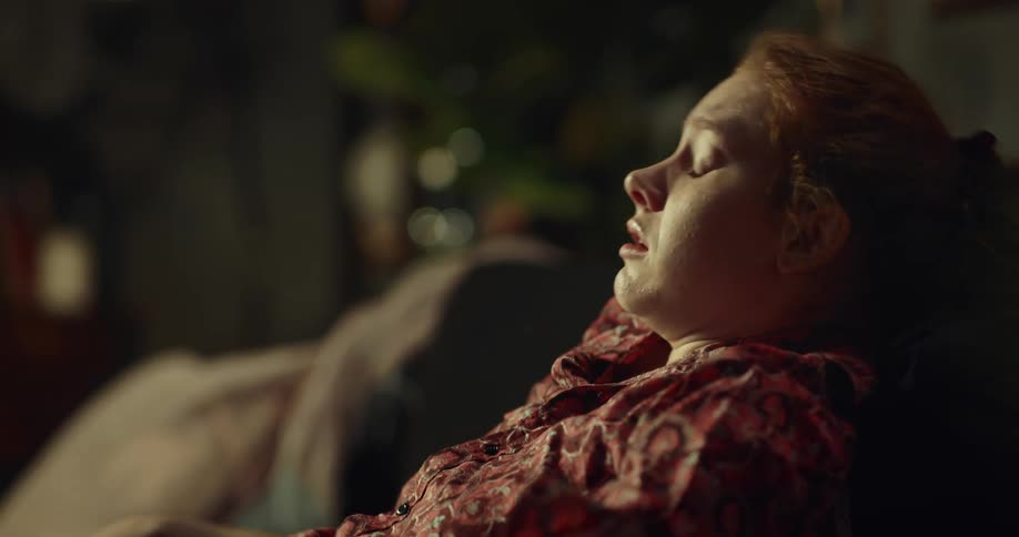 A woman talking a pill while clearly in pain