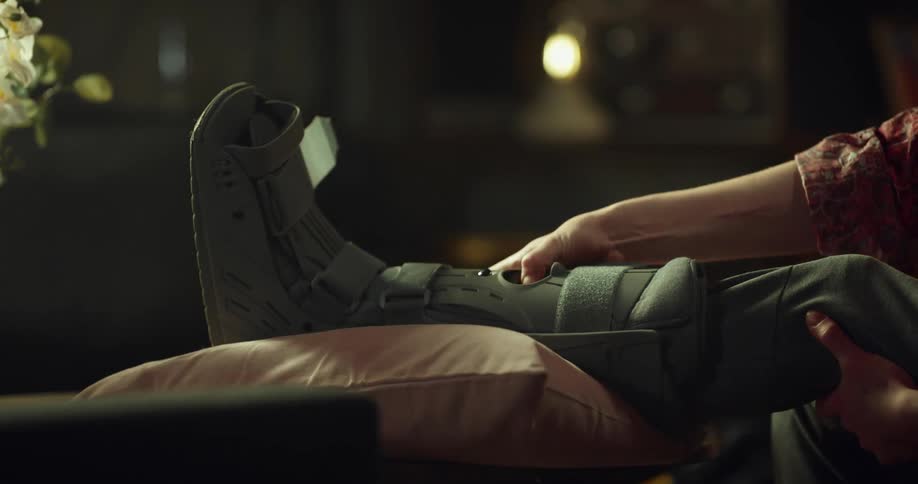 Woman adjusting foot cast on injured foot