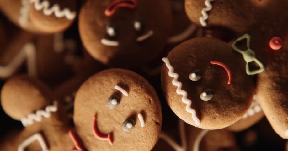 The smiling faces of gingerbread men look up from a tray of holiday cookies