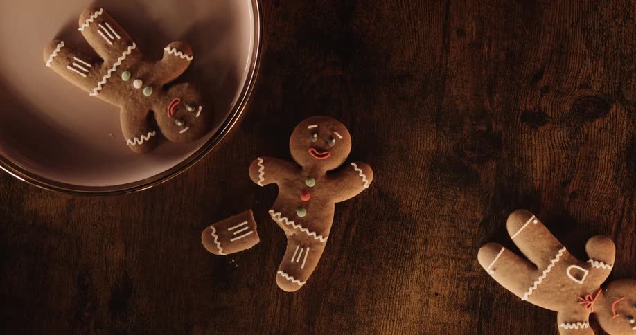 Gingerbread men are on a table and on a plate as one has a broken leg