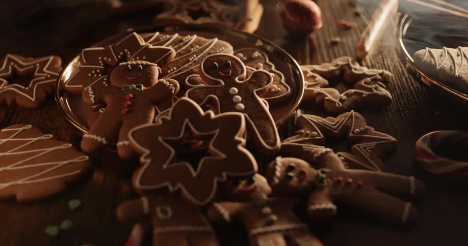A plate of homemade gingerbread cookies in various shapes and decorations is sitting on a wooden tabletop