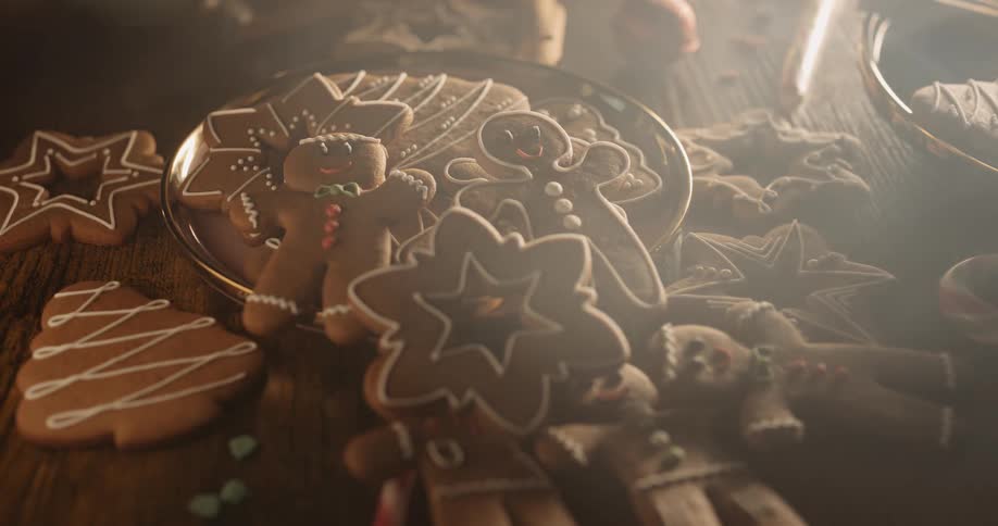 Smiling gingerbread men are looking up from a plate of cookies as smoke floats over the table