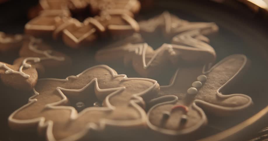 Gingerbread men and other holiday cookies are on a plate as smoke floats over the table