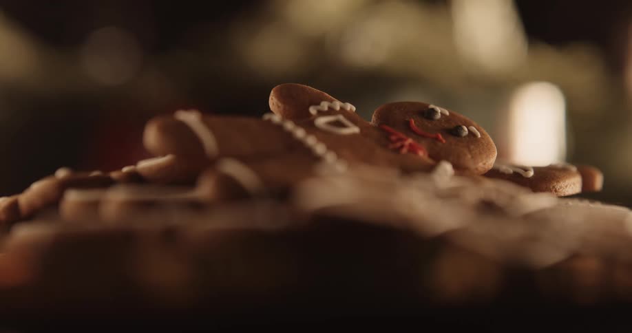 A smiling gingerbread man looks up from the top of a plate of cookies