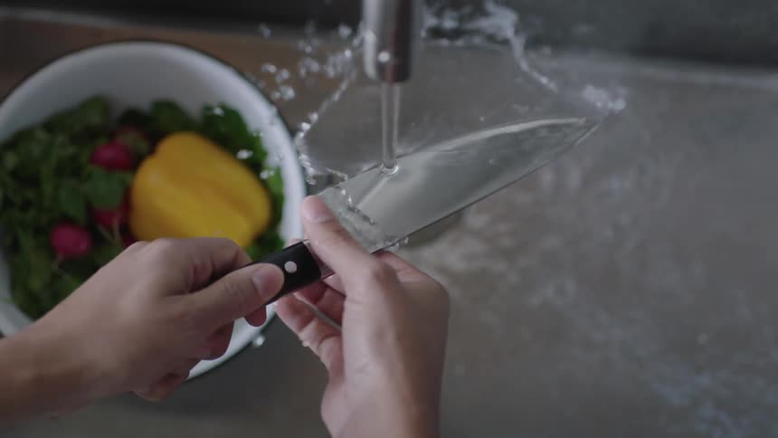 A chef washes a knife