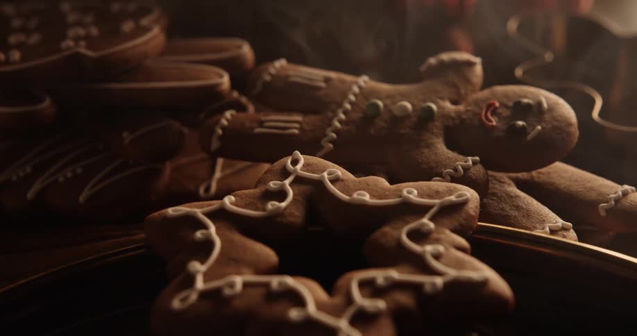 Gingerbread men and other holiday cookies are stacked on the table as smoke floats over them