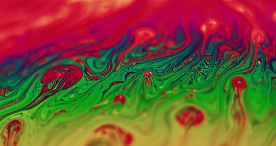 Close up of red yellow and green liquids swirling