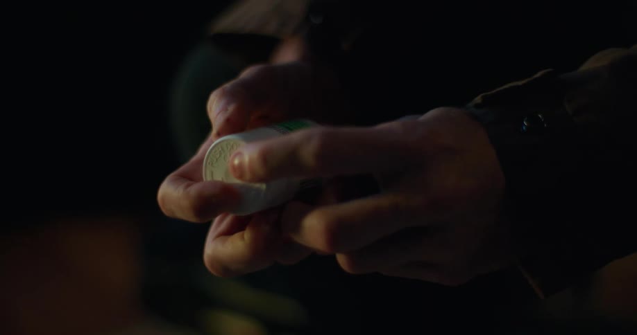 A person holding pills and constantly shaking