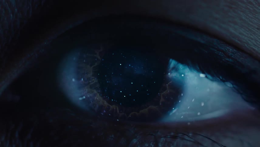 Close view of a human eye with stars from a night sky reflecting on the eye