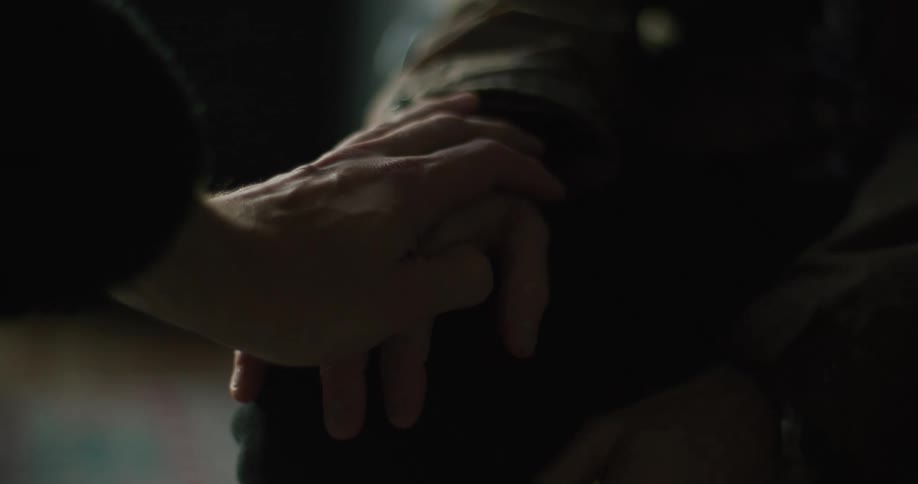 A man shaking before another hand touchs him to comfort him
