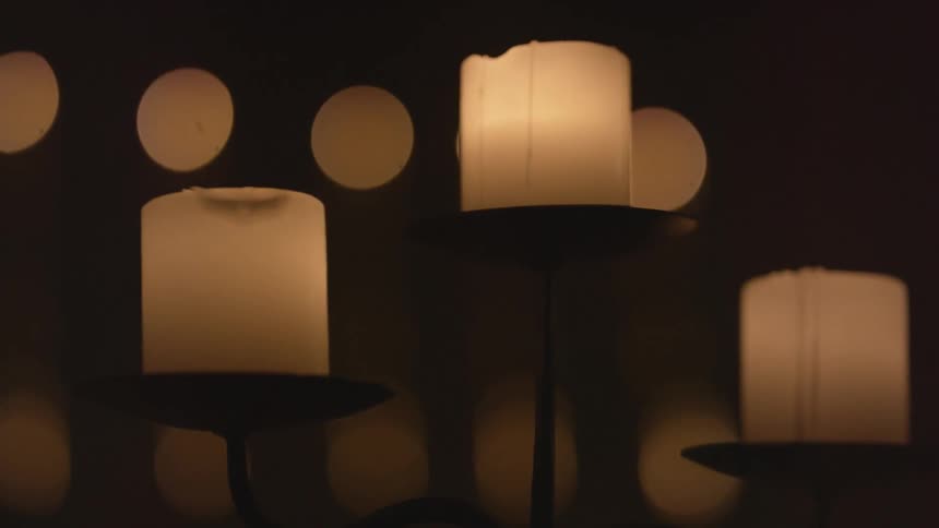 Candles are lit all over this dark room