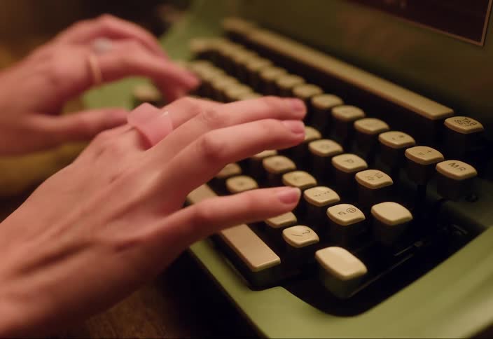 A person is typing on an old fashioned keyboard