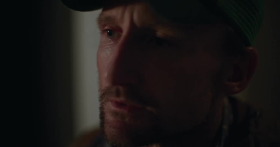 Man takes medication and talks while sitting in dimly lit room