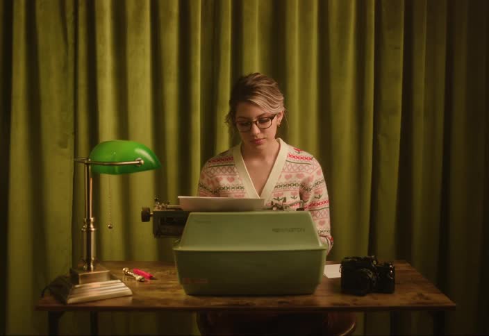 A woman sits in front of the typewriter