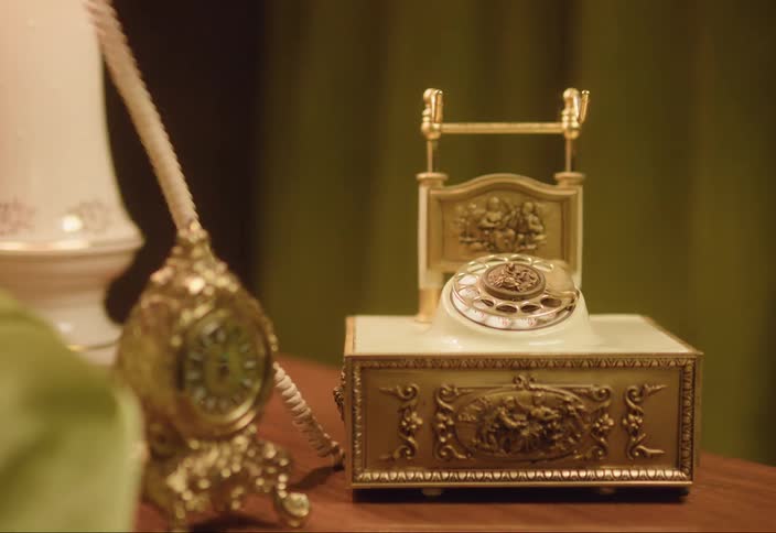 Woman with sweater picks up princess french rotary phone bell