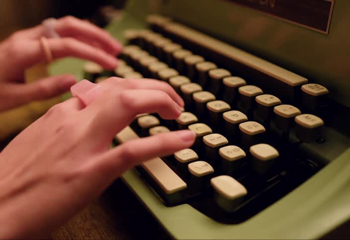 Close up of womans hands using typewriter