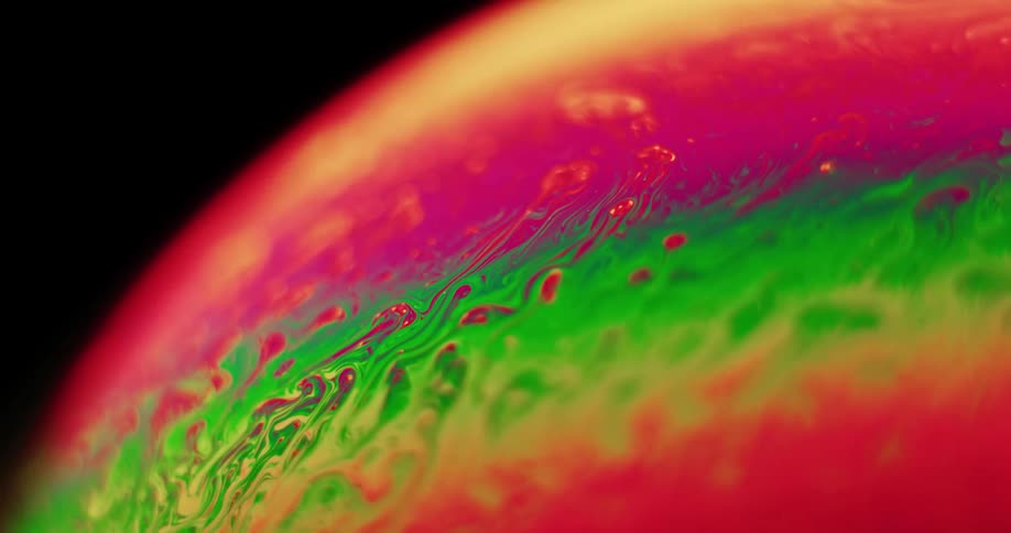 The organic colored surface of a sphere mixes and blends as colors stretch and move as green moves into red and red blends into yellow