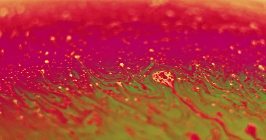 Yellow particles move across the red surface and blend into orange as green moves in from below