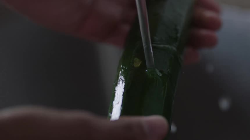 A person washes a cucumber