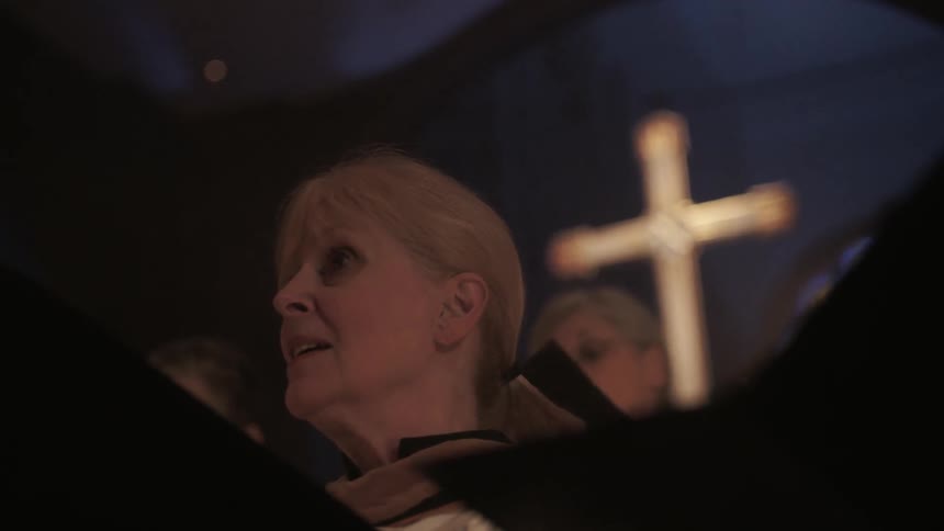 People singing from their books in a religious building