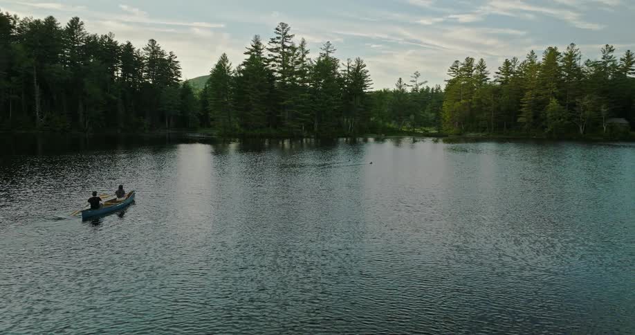 Couple paddling in a canoe on a lake in the wilderness