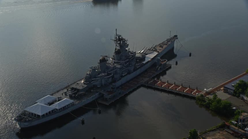 Approaching and flying over the USS New Jersey on the Delaware River in Camden NJ during a partly cloudy day