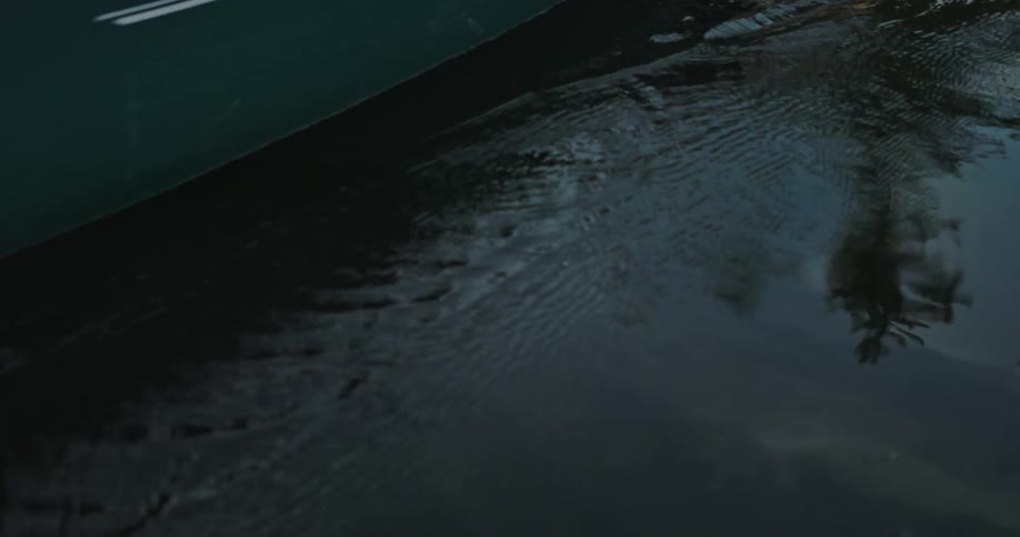 Water reflects woman paddling canoe