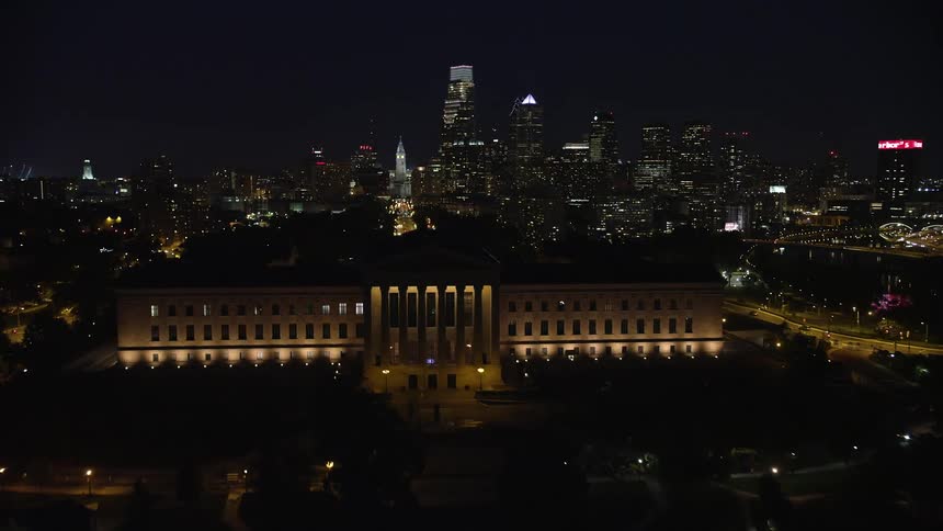Approaching and flying over the Philadelphia Museum of Art in downtown Philadelphia with the city skyline in the background captured at night during summer
