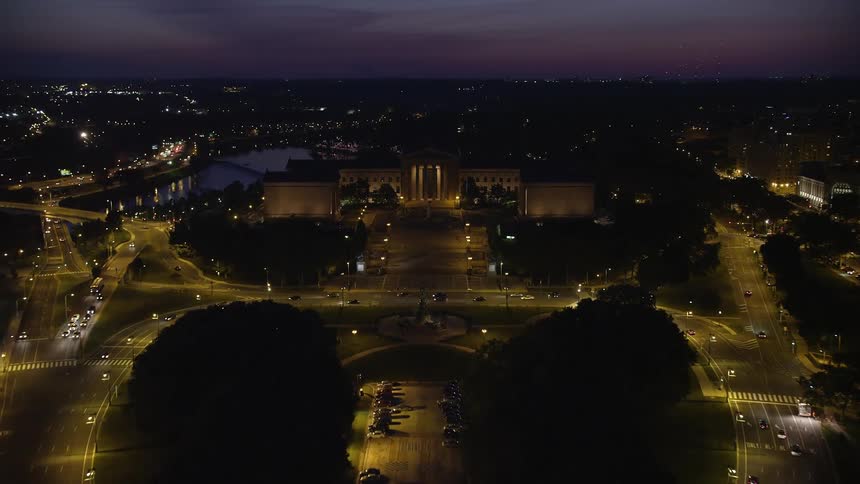A breathtaking aerial view of the famous Philadelphia Museum of Art captured on a cloudy night as traffic runs through the city below