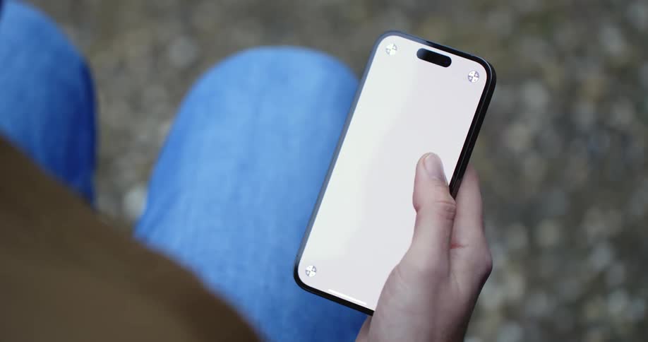 A man scrolls through his phone while sitting outside