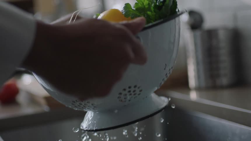 Person rinsing some vegetables in a strainer