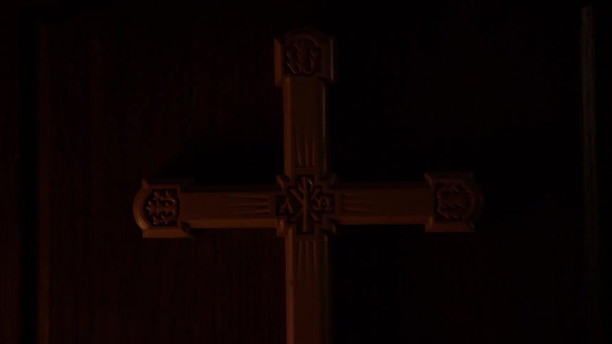 A cross sits in a dark area
