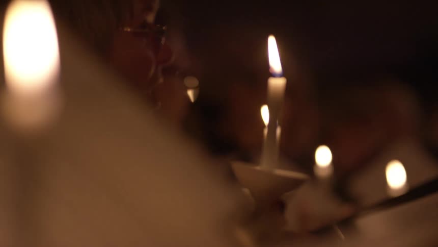 People are holding candles and singing