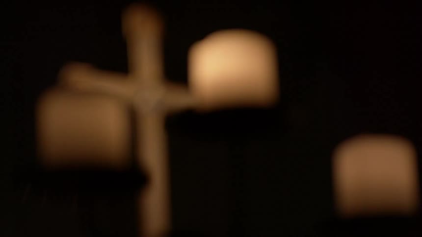 Candles sit in front of this cross