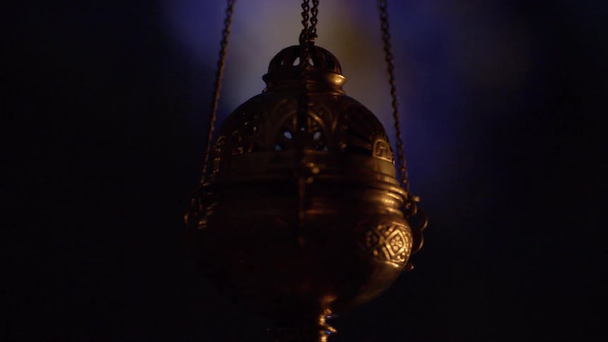 A golden container hanging on chains