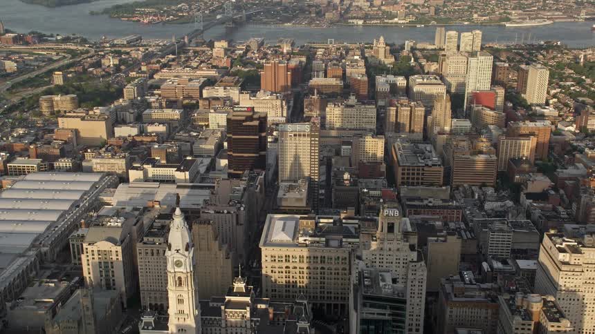 Aerial footage captures the sunset over office and apartment buildings in downtown Philadelphia revealing the iconic structure of City Hall