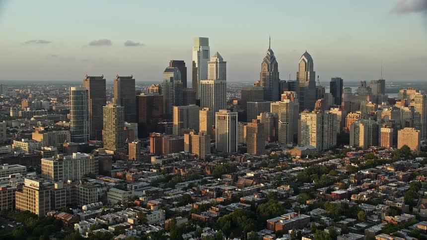 An aerial video capturing downtown Philadelphias towering skyscrapers and urban neighborhoods during sunset