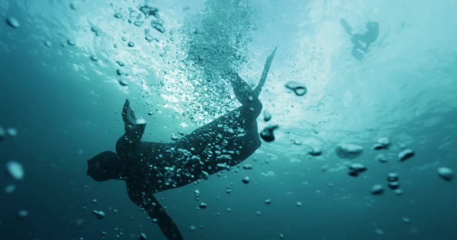 A male scuba diver suspended in turquoise ocean water