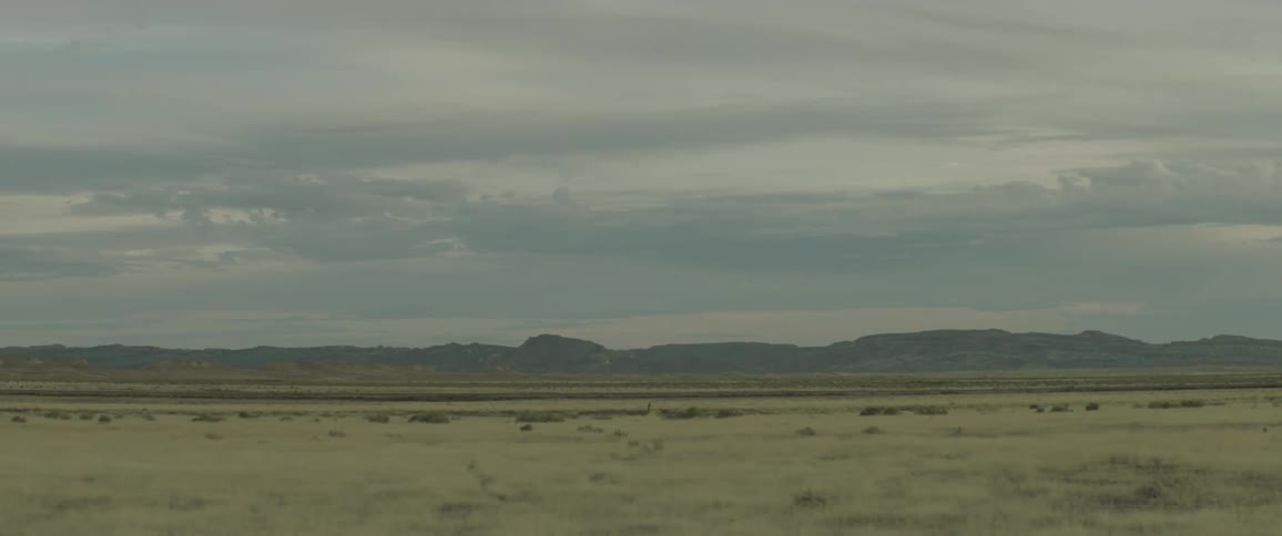 A truck travels down a rural desert road