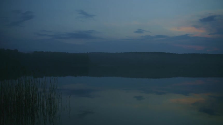 The sun is setting above the lake landscape