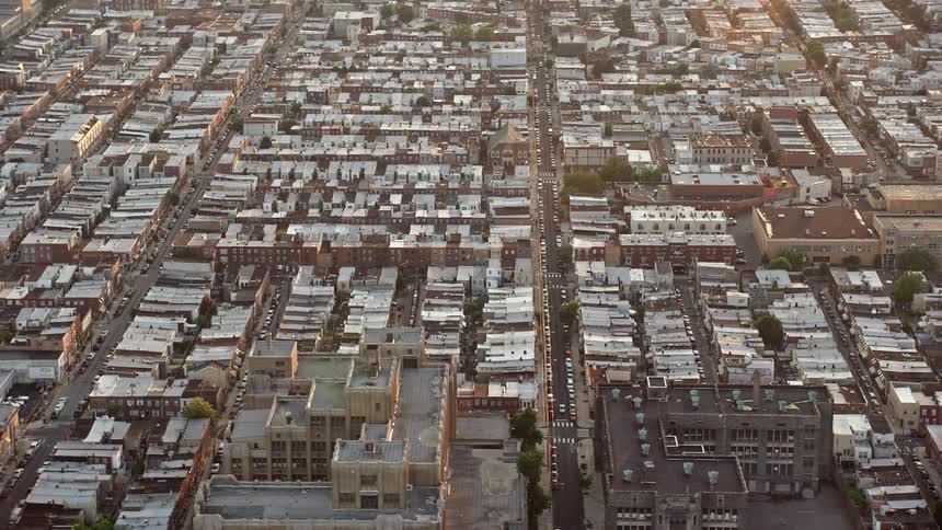 Aerial footage of a residential neighborhood at sunset in South Philadelphia with row houses and clear skies