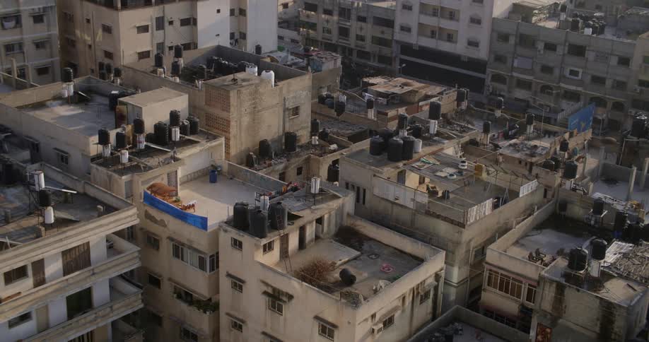 Tanks and furniture sit on roofs of apartment buildings