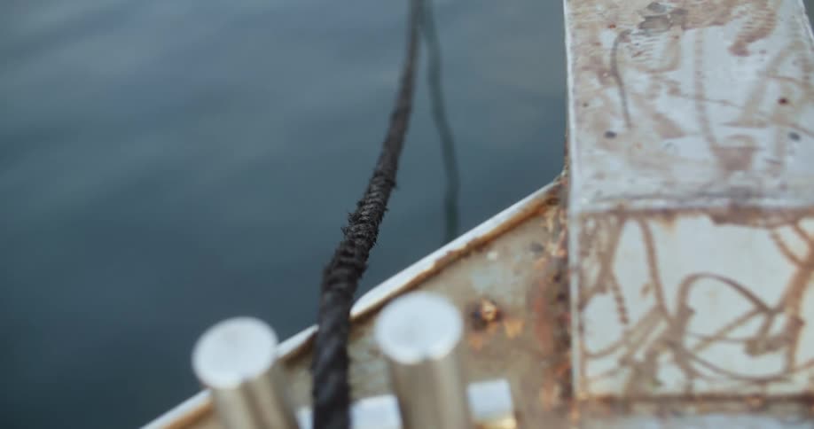 Close up of rope overhanging boat in water