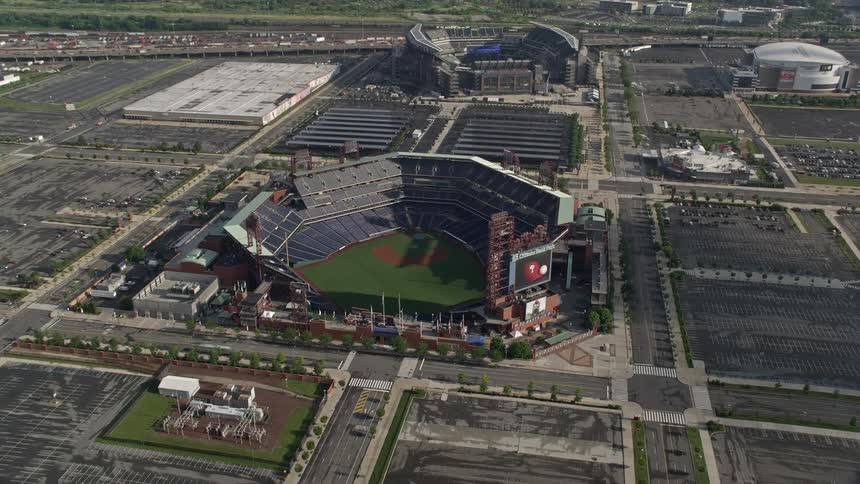 Traffic flows along highways passing sports fields and stadiums with river in distance