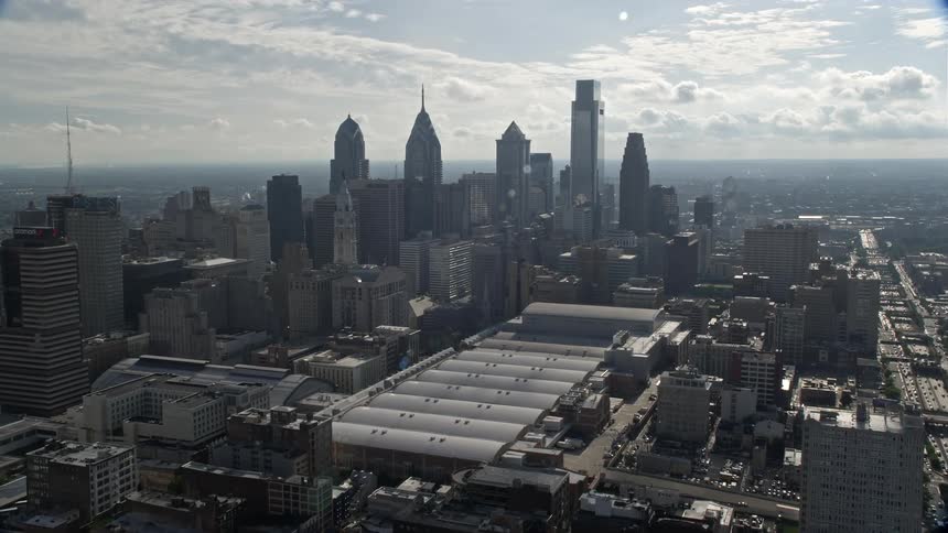 Aerial footage approaching the Philadelphia Convention Center and Downtown Philadelphia skyline on a hazy and sunny day